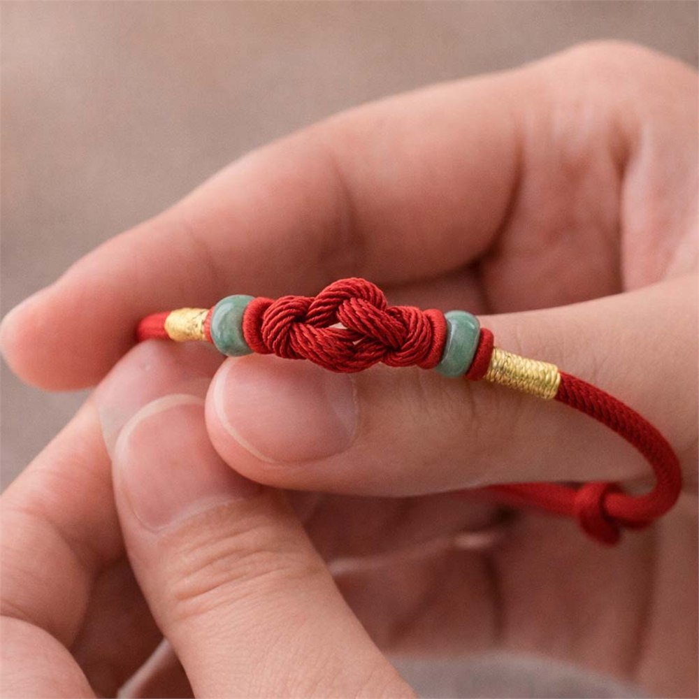 Texture detail of red cord, jade beads, and knot work on the Red Thread of Intention bracelet