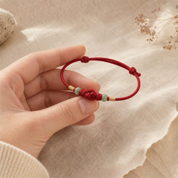Eastern Story Red Thread of Intention Handheld Scale Red Thread of Intention bracelet held in the hand for scale