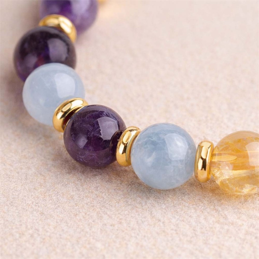 Texture detail of polished gemstone beads and gold-tone spacers on the Strength bracelet