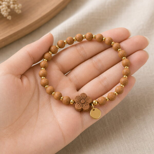 Peach Blossom Sandalwood Bracelet - Handheld Peach Blossom Sandalwood Bracelet, product held naturally in one hand