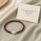 Quiet Glow Garnet & Pale Stone Bracelet, product on premium textile with a meaning card