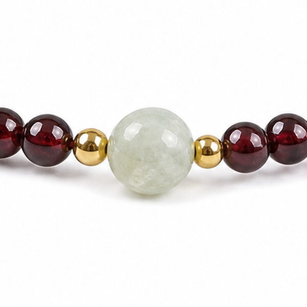 Quiet Glow Garnet & Pale Stone Bracelet - Detail Quiet Glow Garnet & Pale Stone Bracelet, close detail of beads, centerpiece, cord, and drop
