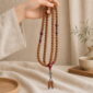 Red Harmony 108-Bead Bodhi Seed Mala, mala draped naturally from one hand