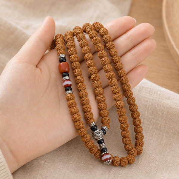 Rising Sun 108-Bead Bodhi Seed Mala - Handheld Drape Rising Sun 108-Bead Bodhi Seed Mala, mala draped naturally from one hand