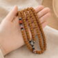 Rising Sun 108-Bead Bodhi Seed Mala, mala draped naturally from one hand