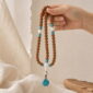 Still Waters 108-Bead Bodhi Seed Mala, mala draped naturally from one hand