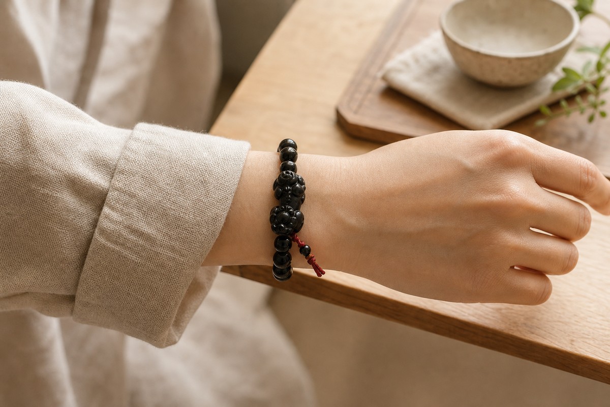 Black obsidian Pixiu bracelet worn on a wrist with the charm facing outward