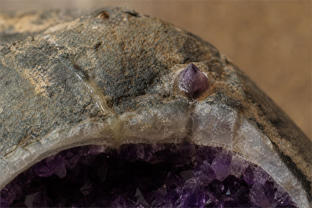 Close view of clear resin in a fracture, a glued crystal, and a straight join on a geode