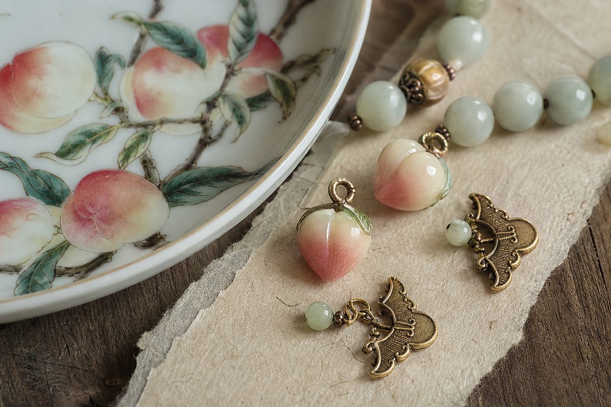 Porcelain peach motif detail with small blessing charms and jade beads for Five Blessings symbolism