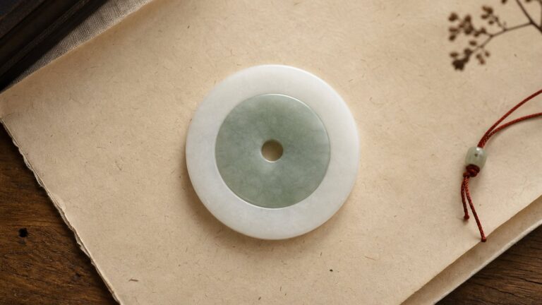 Concentric double-disc jade on parchment with a restrained red cord