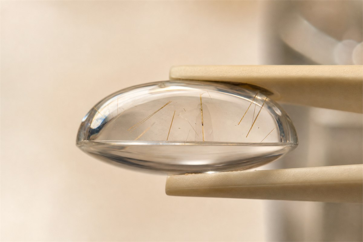 Side-profile macro of a transparent cabochon with a thin planar join between an included upper dome and clear backing