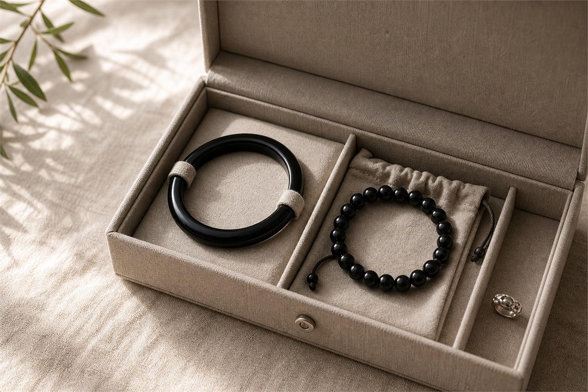 Black agate bangle and bead bracelet stored separately in lined compartments and a soft pouch