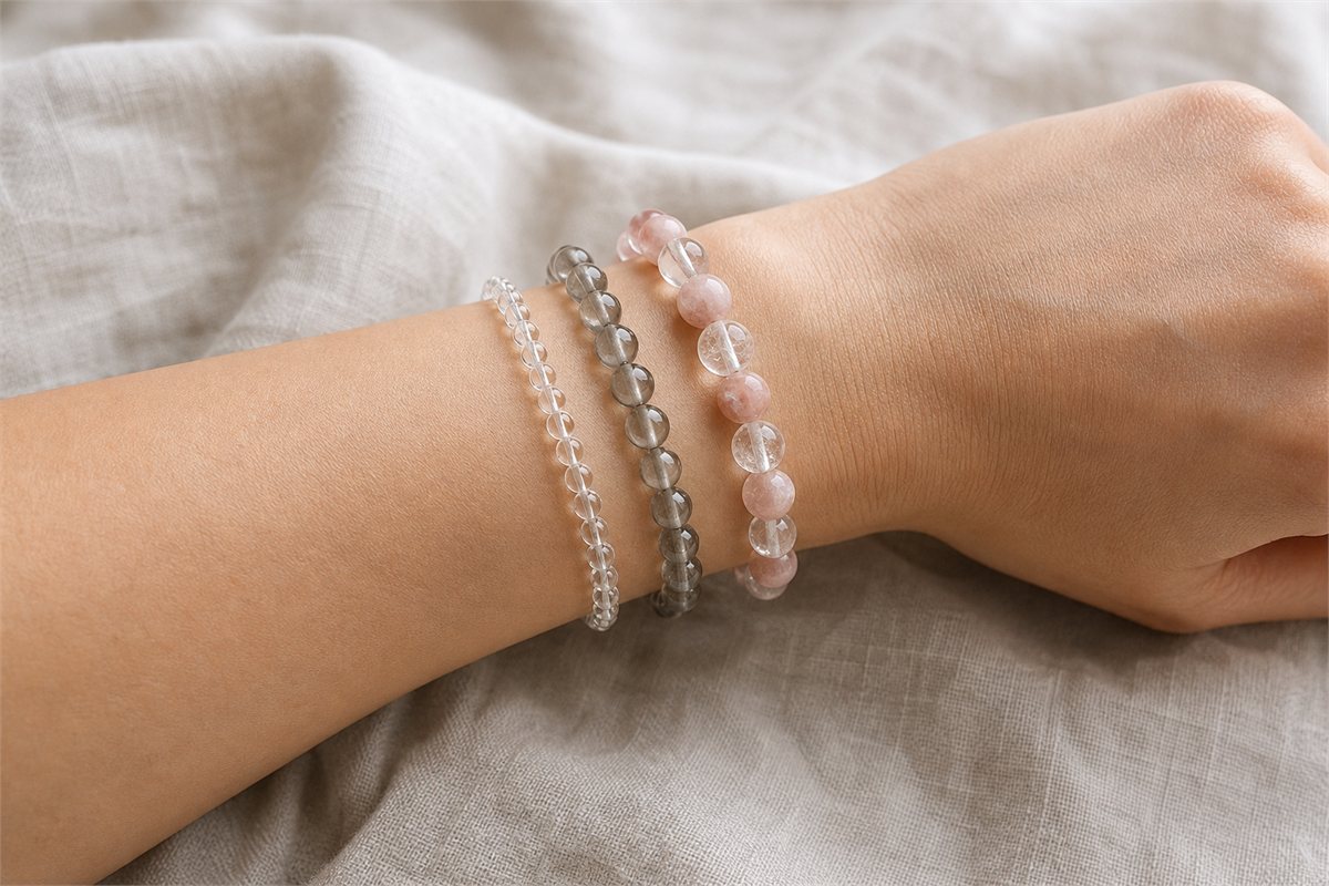 A wrist wearing fine, medium, and larger crystal bracelets with comfortable spacing and no skin indentation