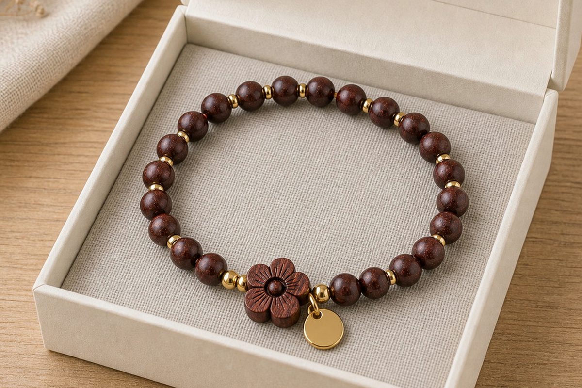 Dark wood bracelet resting in a neutral box with linen and soft daylight
