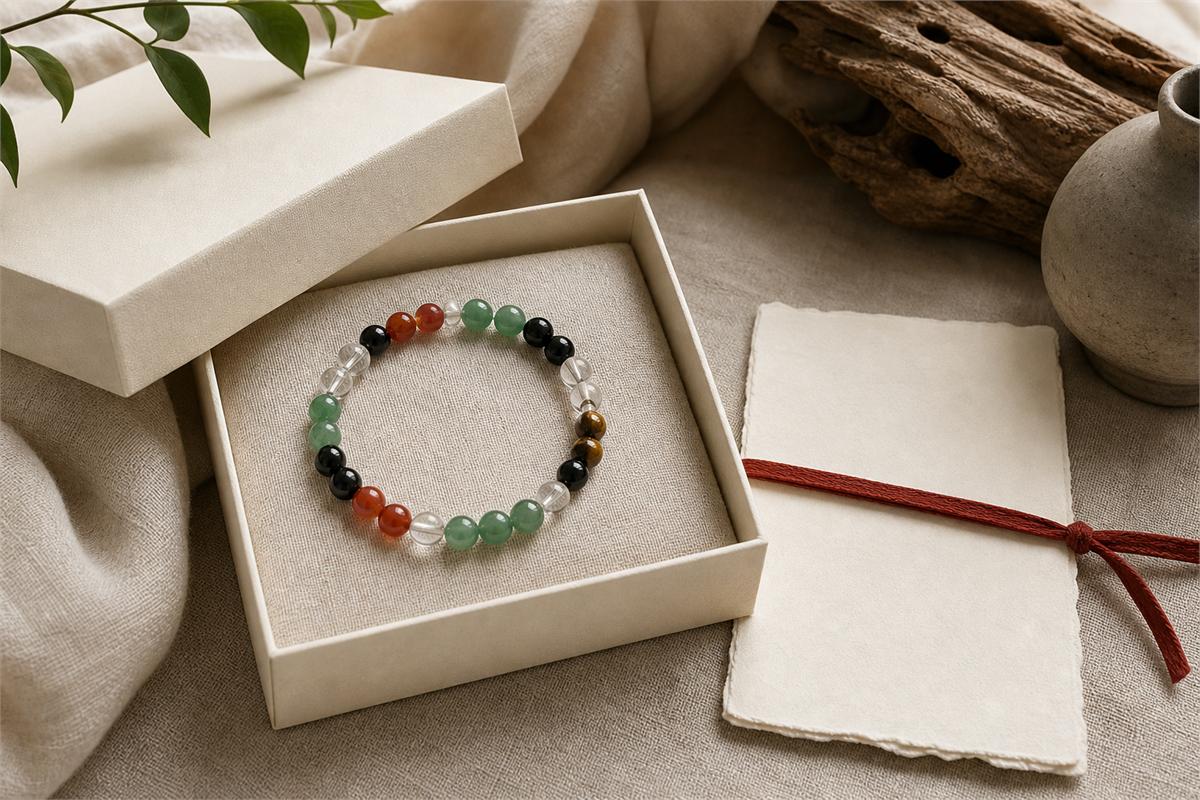 A five-color gemstone bracelet in a neutral paper box with a blank material and care card