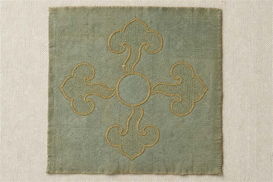 Four ruyi-cloud units arranged around a circular center on celadon silk