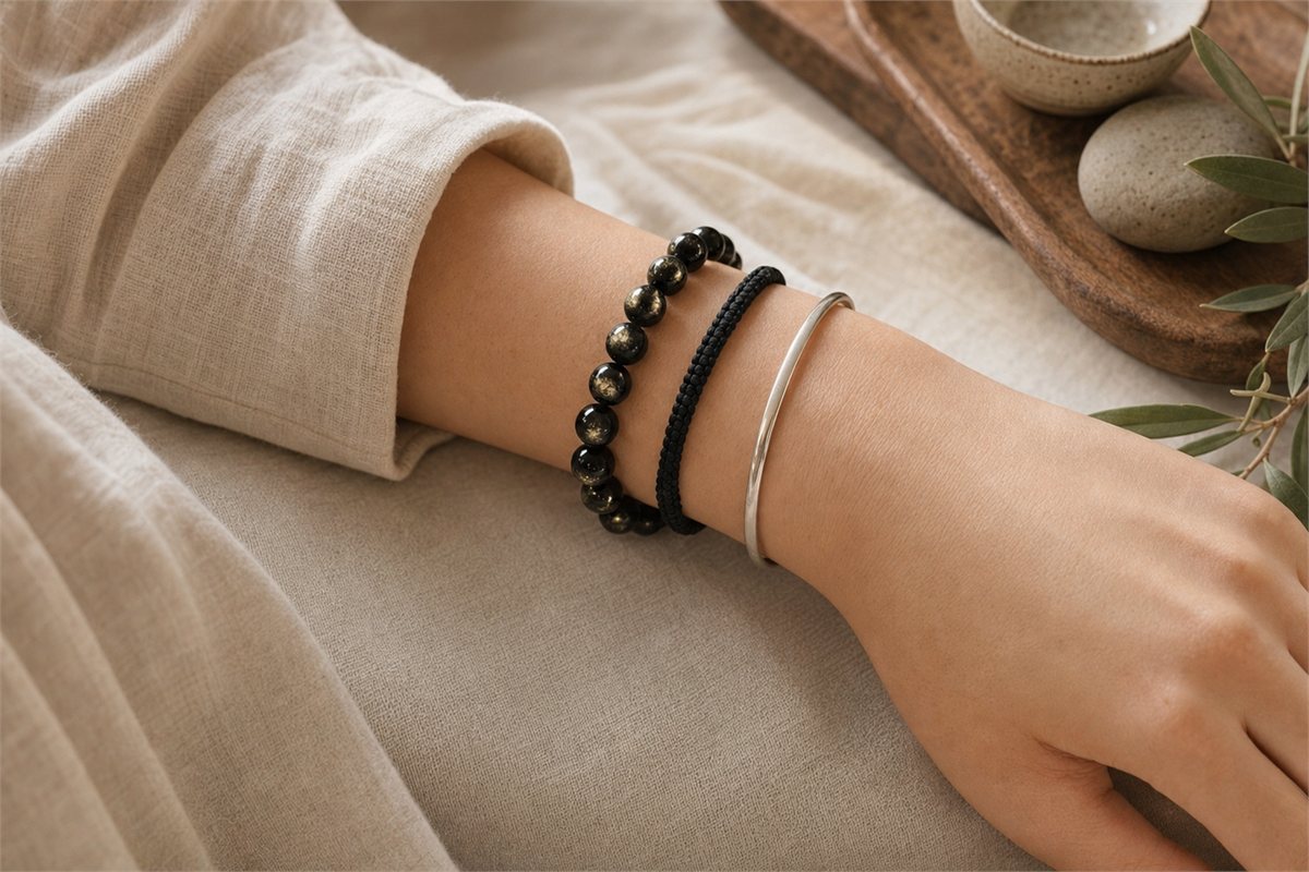 Gold sheen obsidian bracelet stacked with soft black cord and a smooth silver bangle