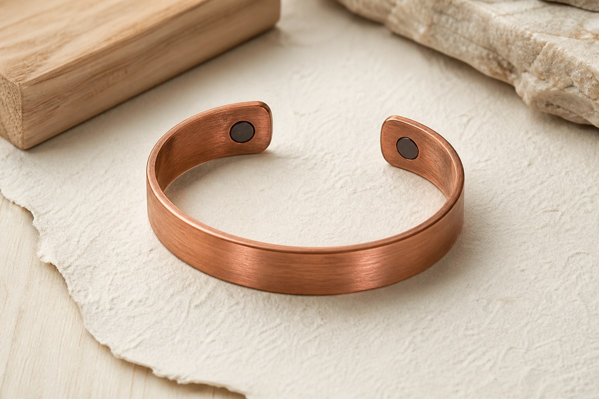 Inner side of a red copper cuff with two flush dark magnetic terminal inserts