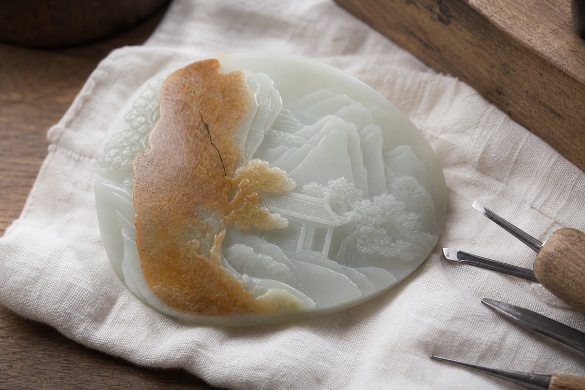 Pale jade-like carving detail using a honey-brown natural skin patch as a visual accent