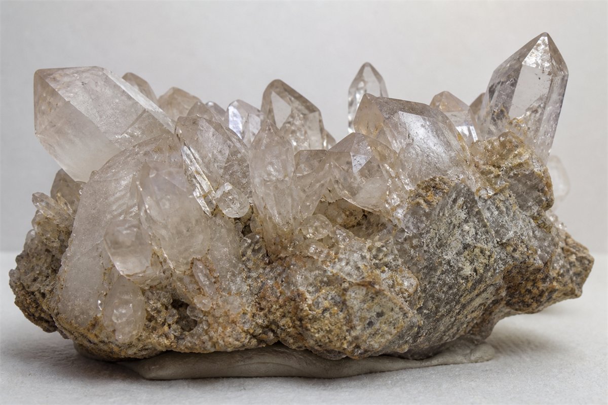 Underside of a quartz cluster showing rough matrix, attachment zones, partial crystals, and contacts