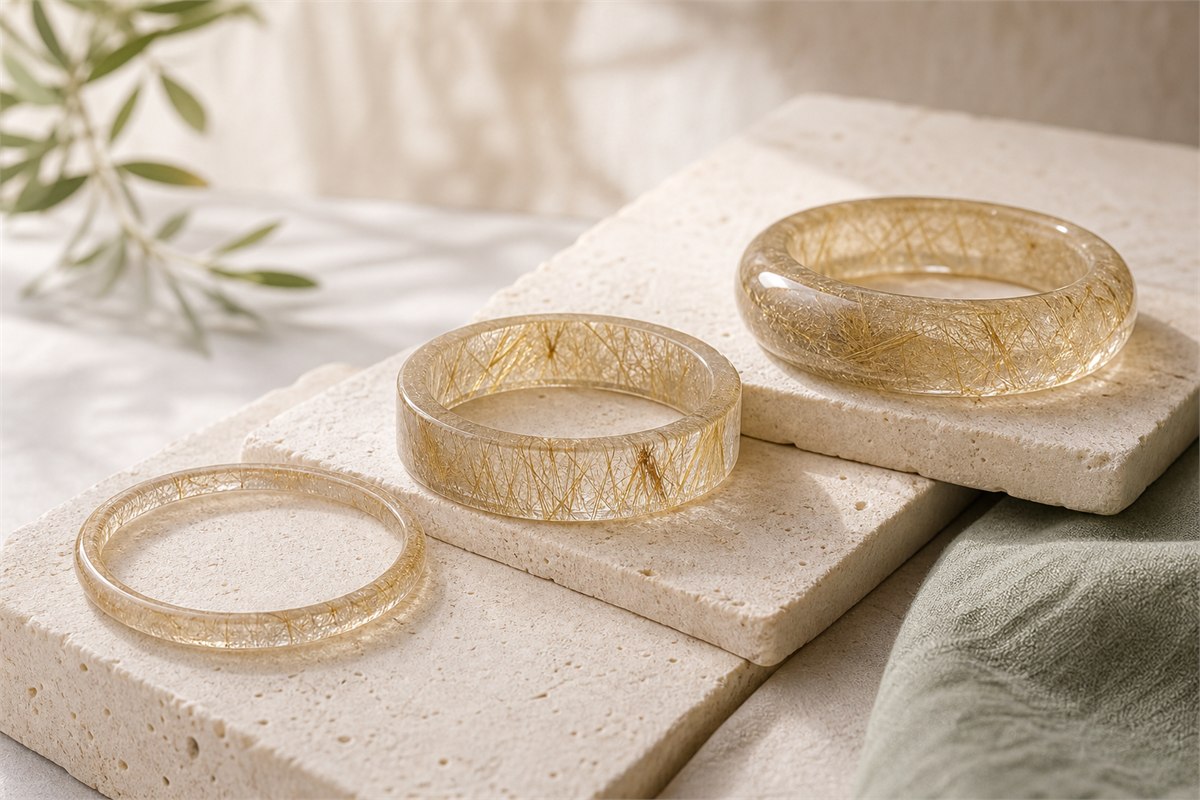 Three closed rutilated quartz bangles with narrow round, broad flat, and thick rounded profiles