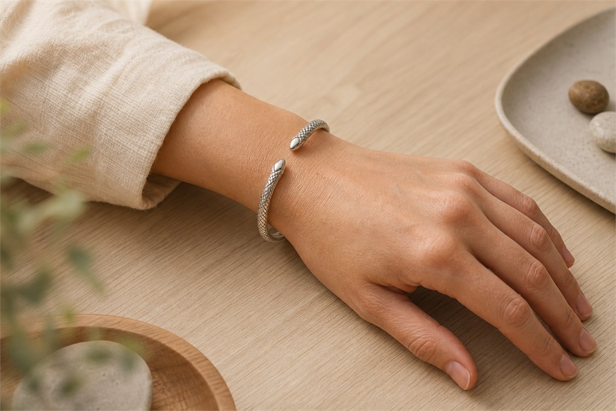 Silver snake cuff resting above the wrist bone with a comfortable open gap