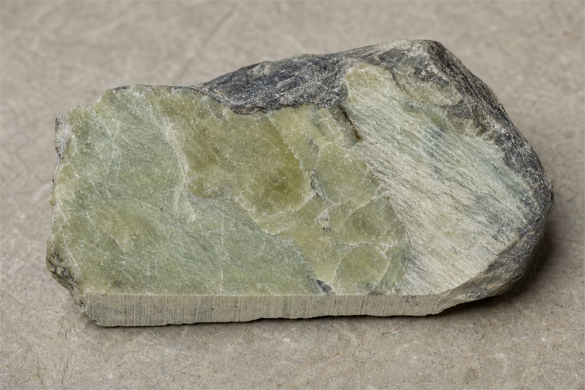 Cut Xiuyan-region rock with irregular pale serpentine and grey-green tremolite-rich zones
