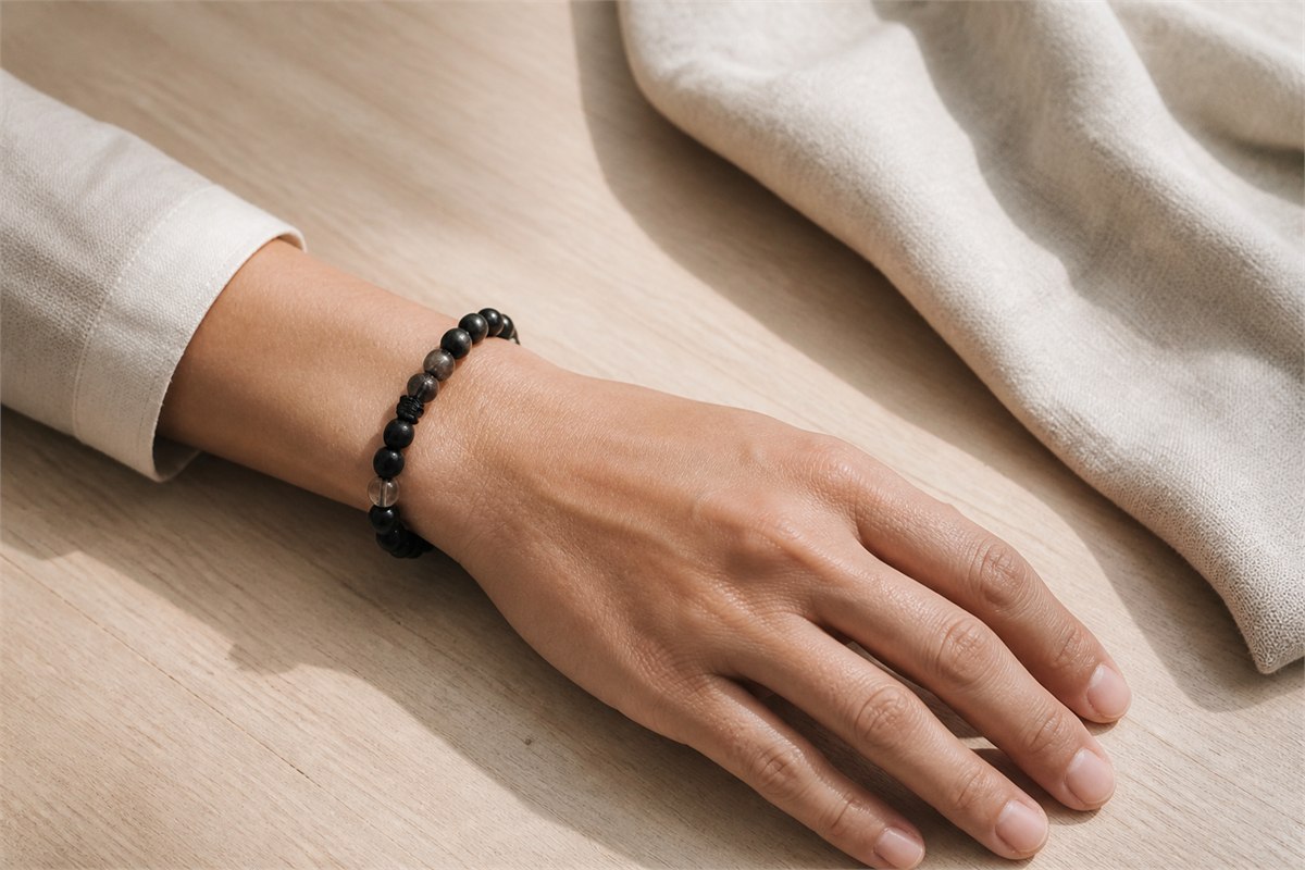 Adult wrist wearing a black tourmaline and smoky quartz bracelet with relaxed spacing.
