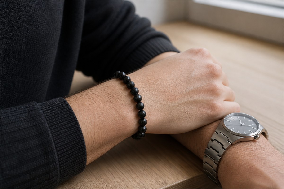 Black tourmaline bracelet and stainless-steel watch worn on opposite wrists