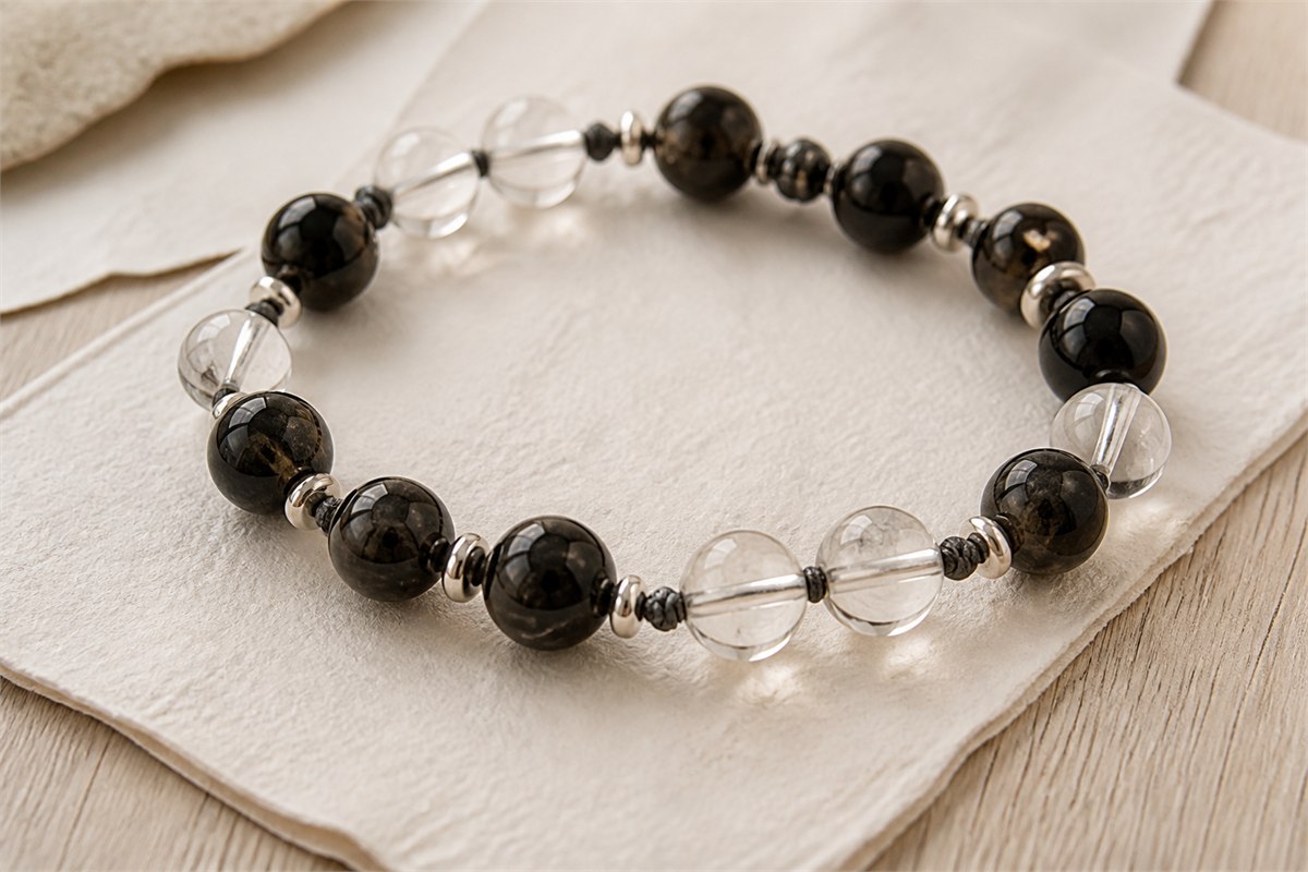 Black tourmaline and transparent clear quartz beads joined with dark cord and matte metal spacers.