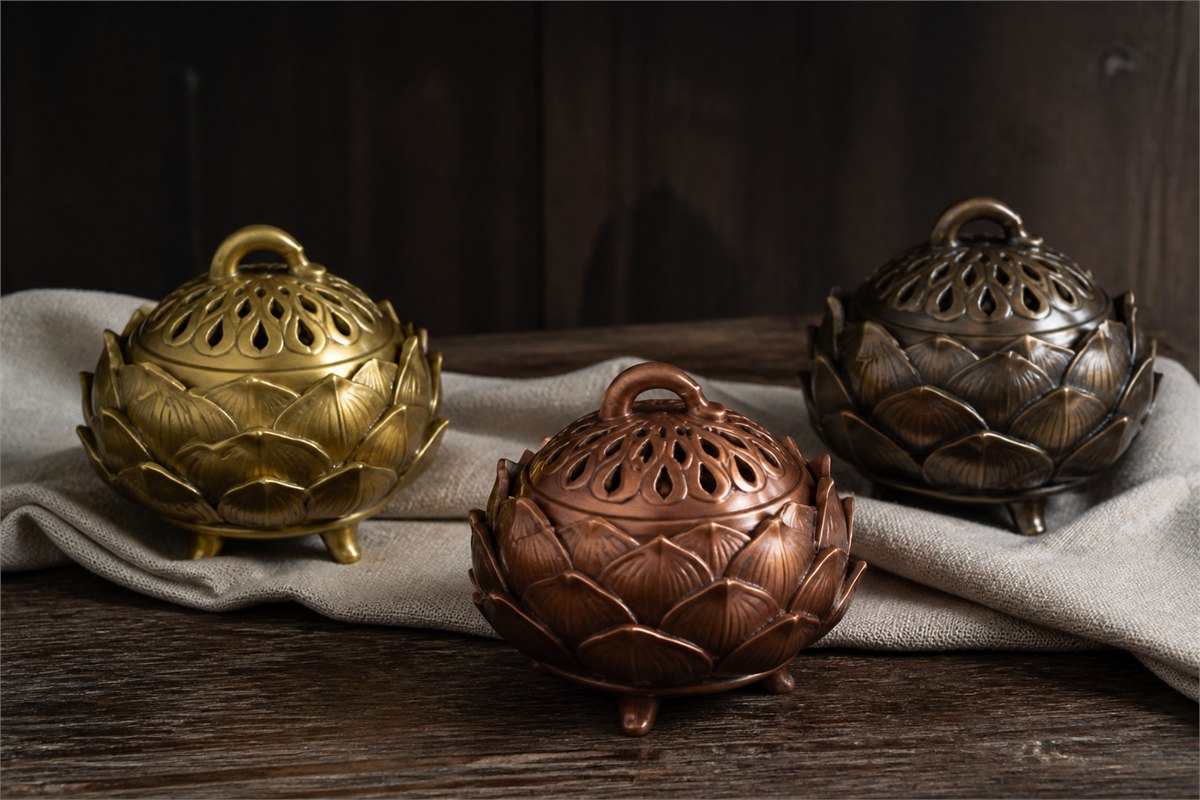 Brass, reddish copper, and dark bronze lotus censers with ventilated lids
