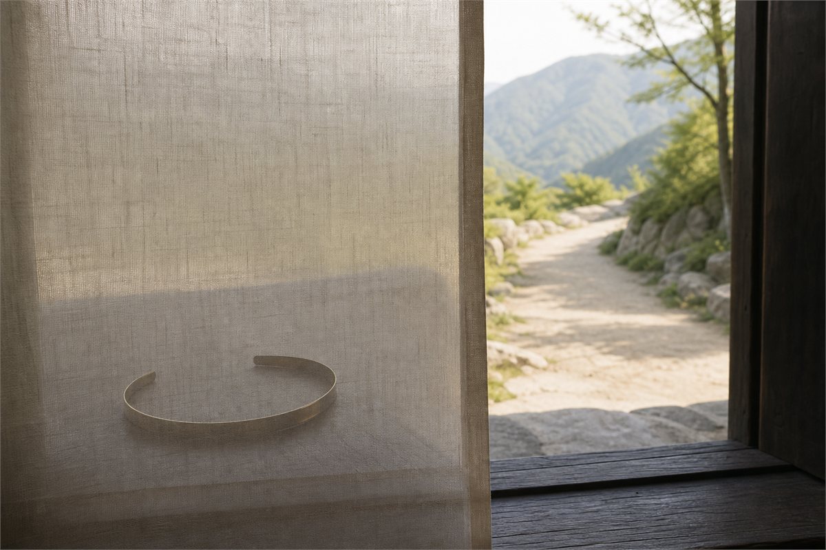 A plain metal fillet behind a translucent linen screen beside an open mountain path
