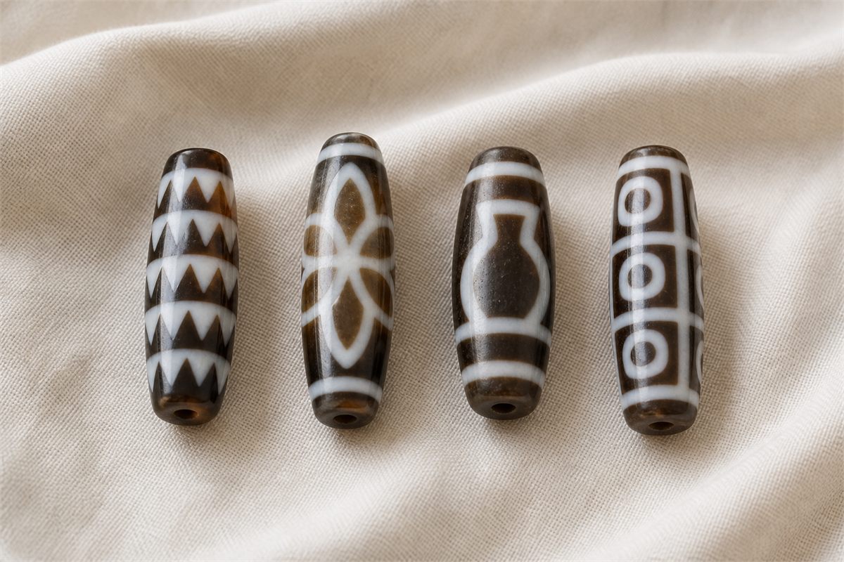 Four modern agate beads with tiger-tooth, lotus, vase, and round-and-square geometric patterns