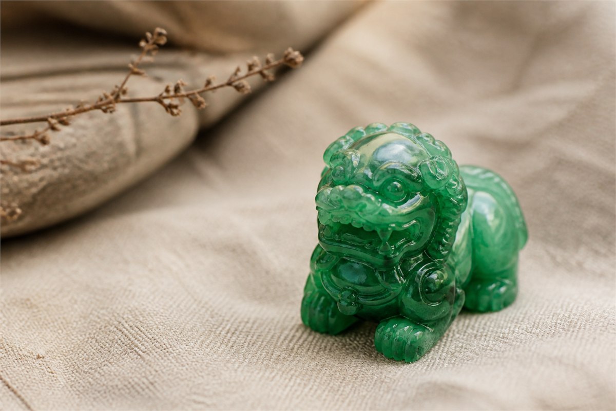 Translucent green jadeite guardian lion carving on warm neutral linen