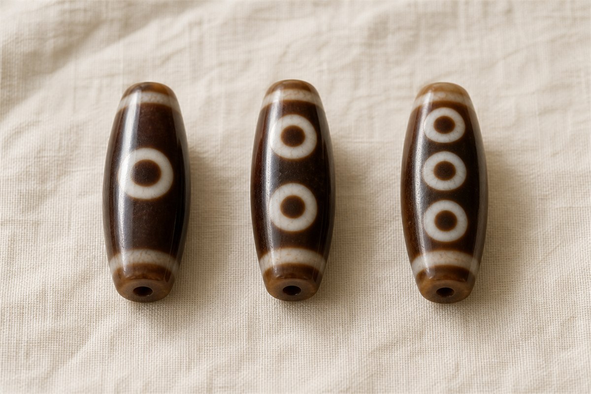 Three modern agate beads showing one, two, and three clearly countable eye motifs