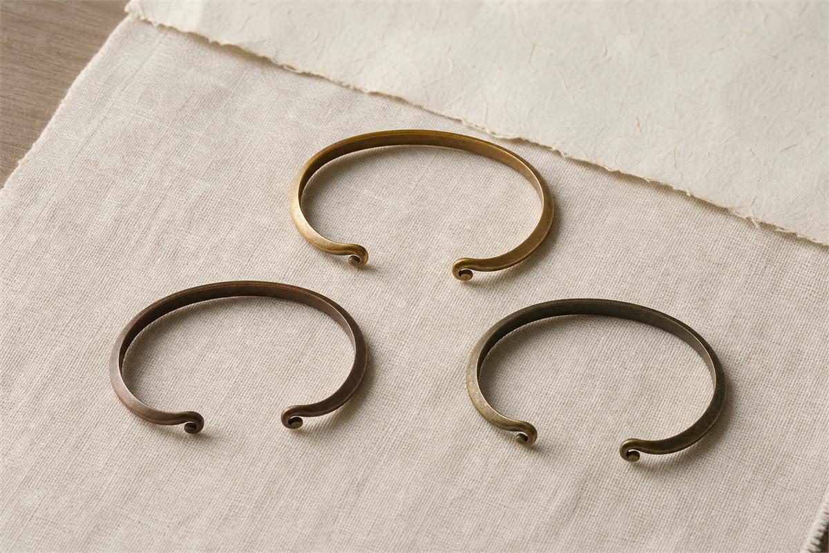 Three separate simple metal forehead fillets arranged on ivory linen