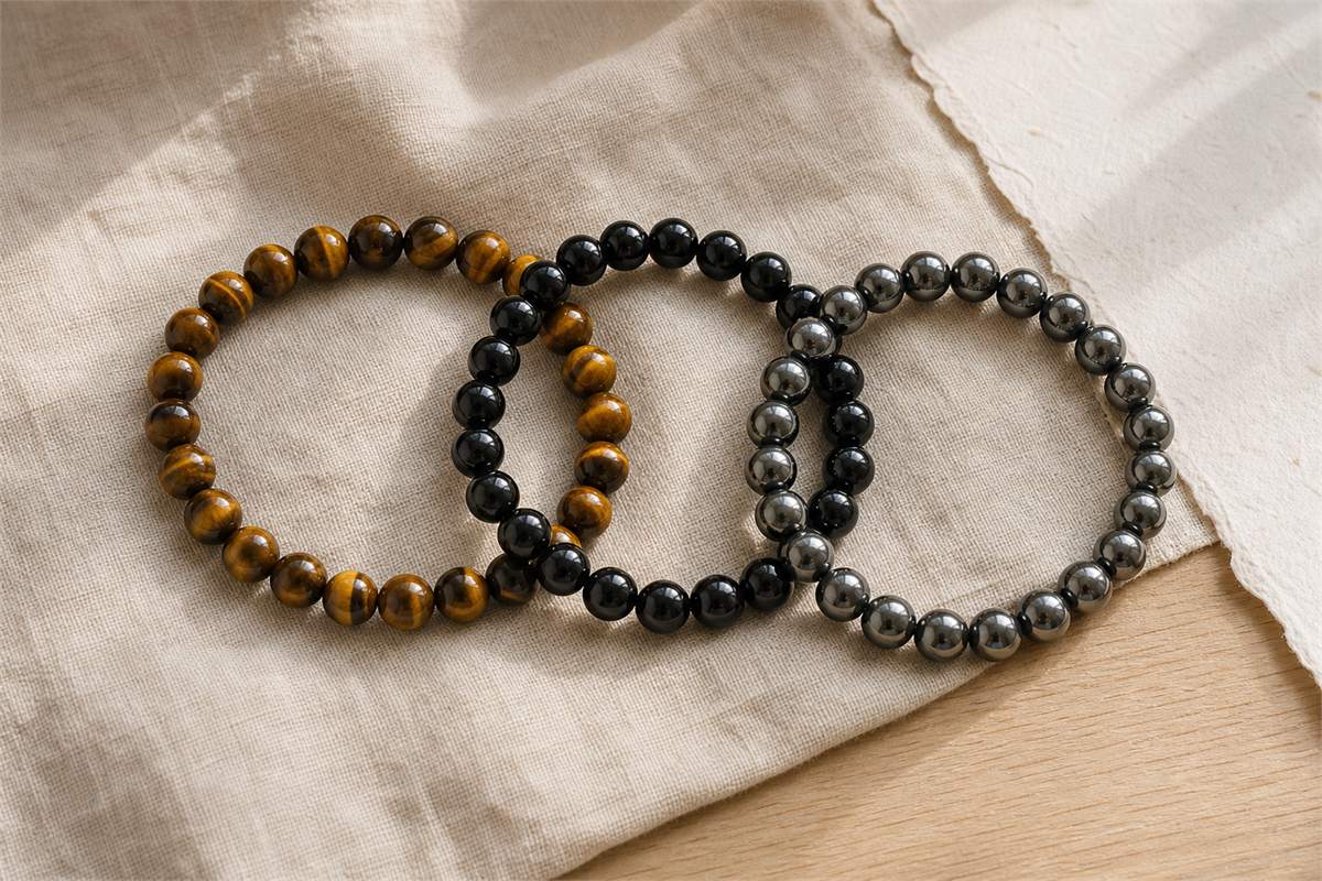 Three overlapping bracelets made from tiger’s eye, black obsidian and hematite beads