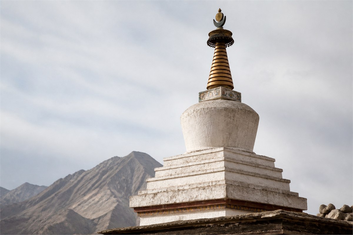 White Tibetan chorten showing a stepped base rounded vase and tapering spire