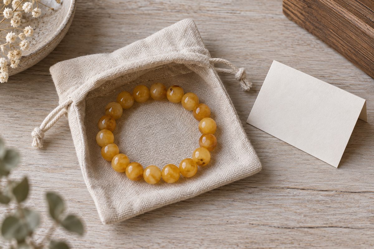 Creamy amber beads rest inside an open linen pouch.