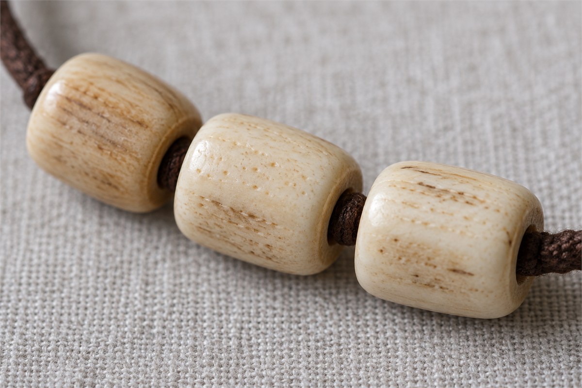 Cream and tan bone beads showing fine surface pores in daylight.