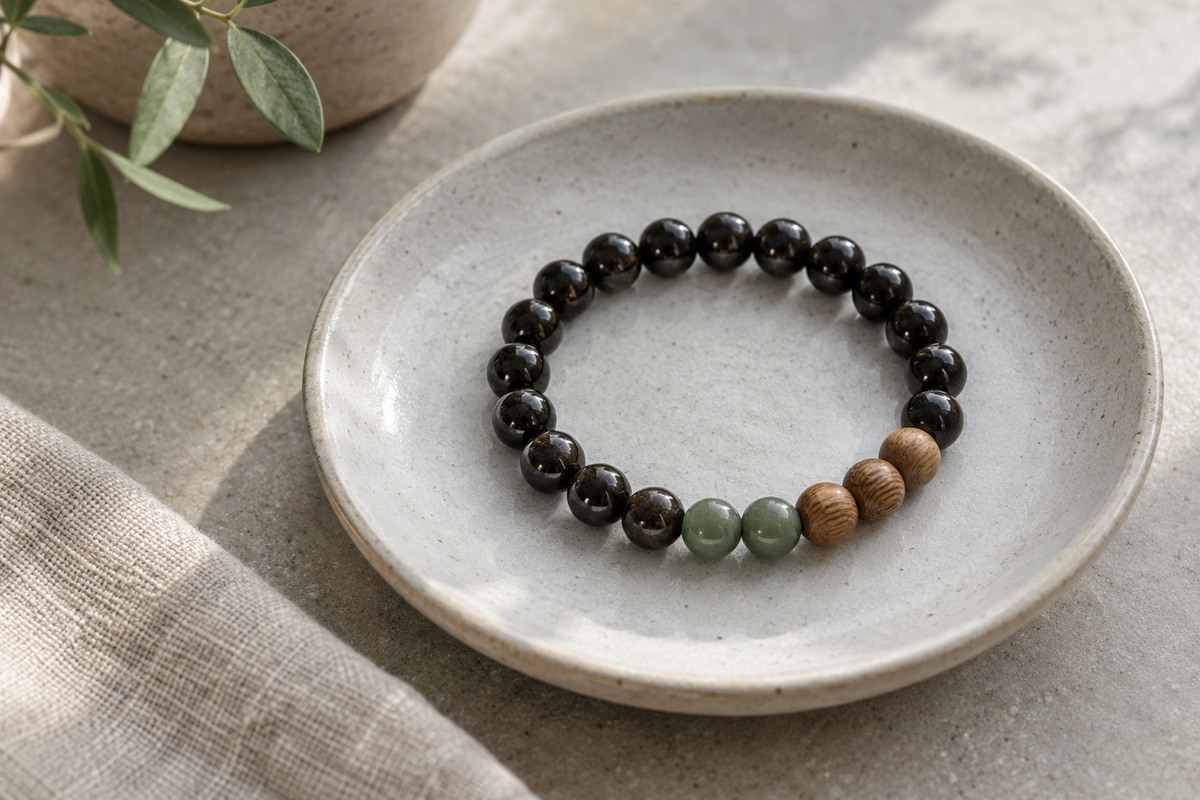 A contemporary bracelet combines dark beads, two muted green beads and several natural wood beads.