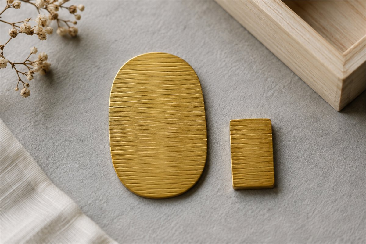 Simplified oval and rectangular gold-colored coin shapes on pale paper.