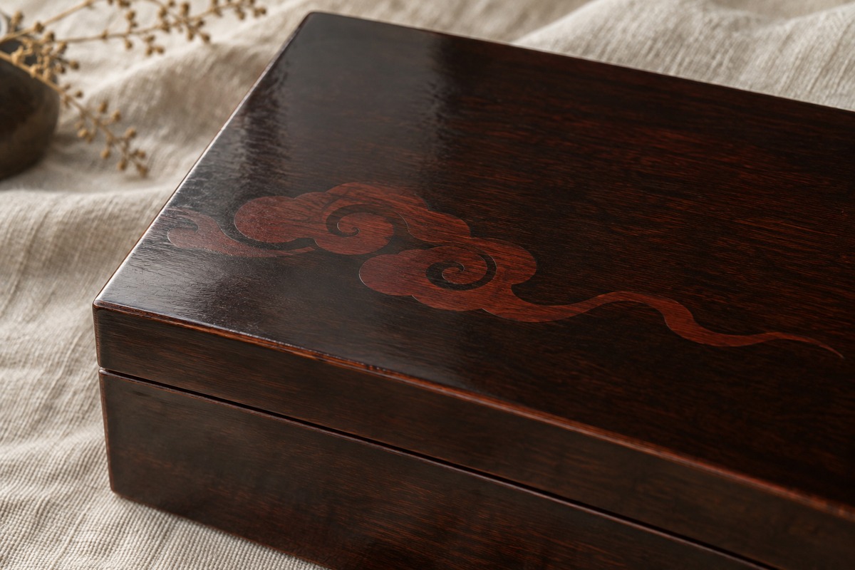 A dark brown lacquer lid bears a restrained flowing cloud motif.