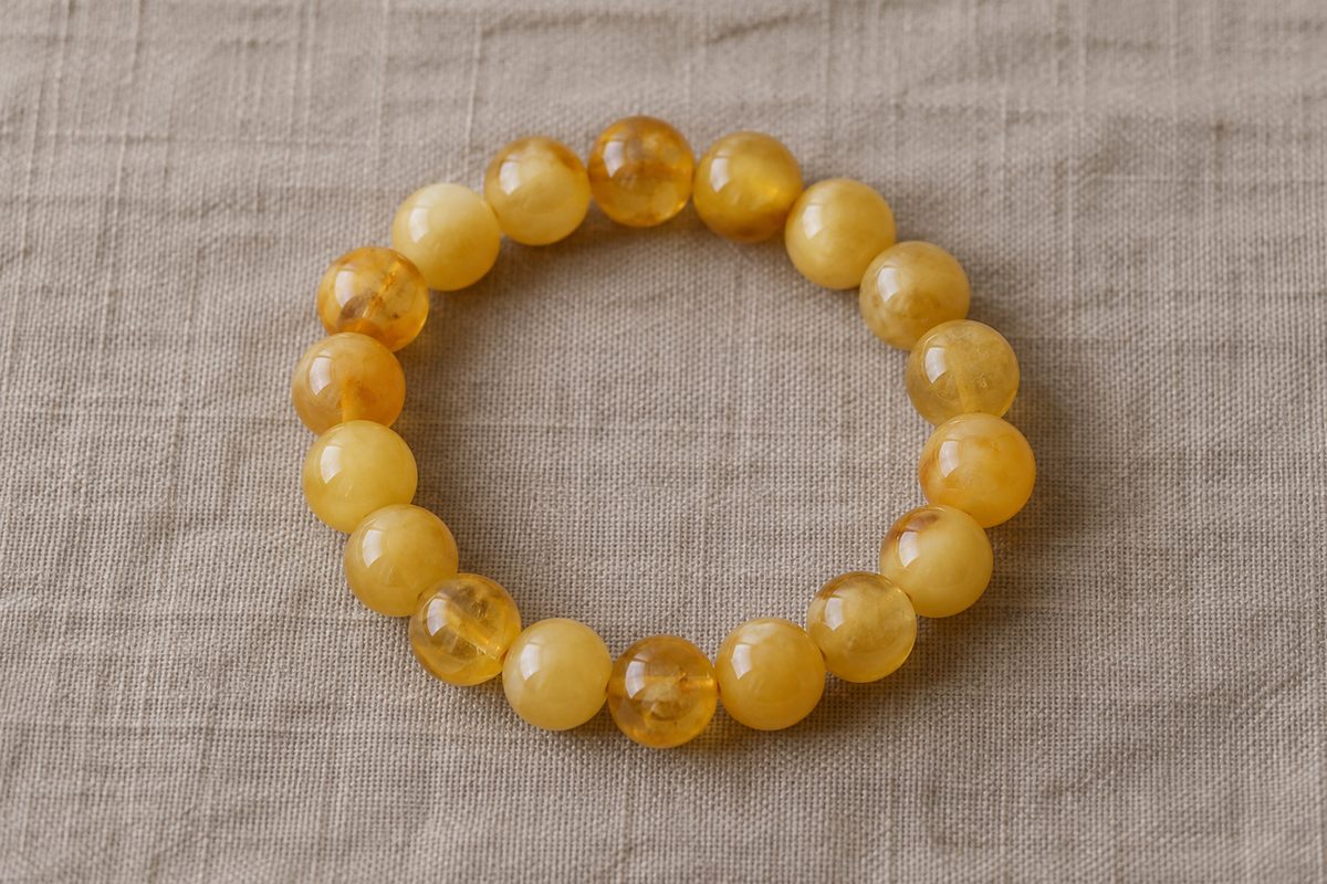 Complete bracelet of round cream and honey-colored amber beads