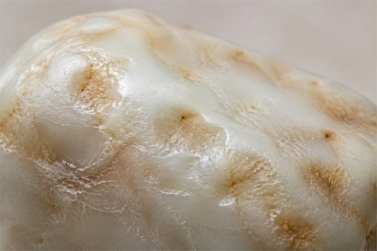 Shallow irregular depressions across a cream and tan stone surface.