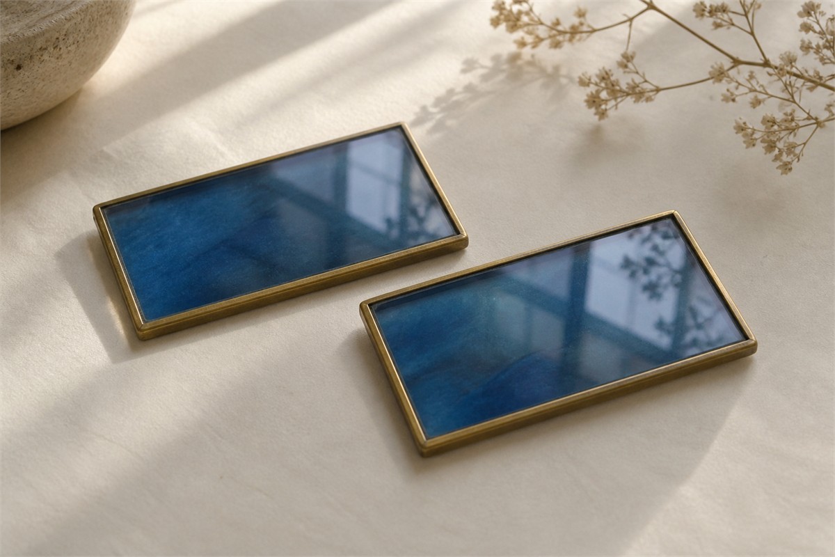 Two rectangular blue glass plaques in thin gold-colored frames.