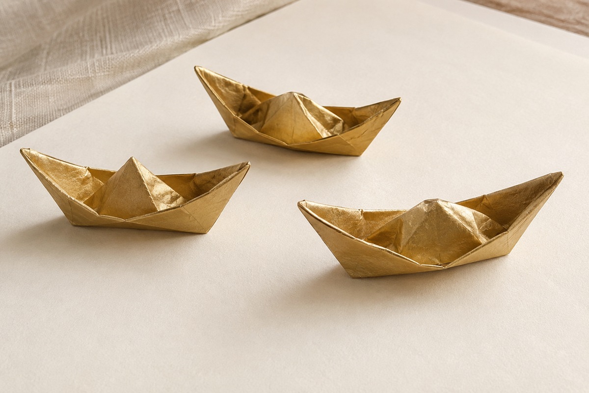 Three boat-shaped gold-colored paper ornaments show crisp folded edges.