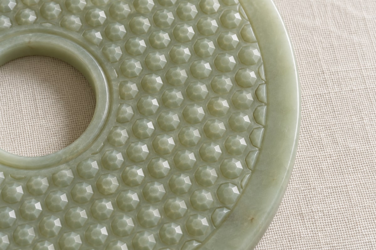 Faceted puwen rows ending at the curved rim of a modern jade bi disc