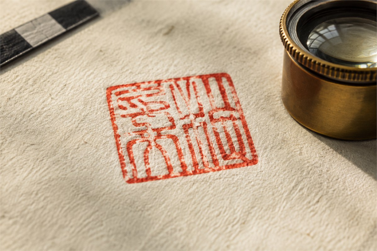 Macro view of a hand-stamped red seal impression with visible paper fibers and border variation