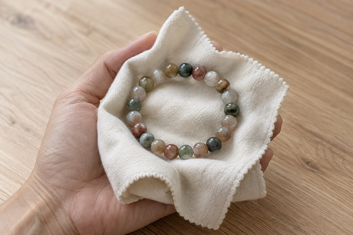 A soft dry cloth gently supporting a multicolor bead bracelet